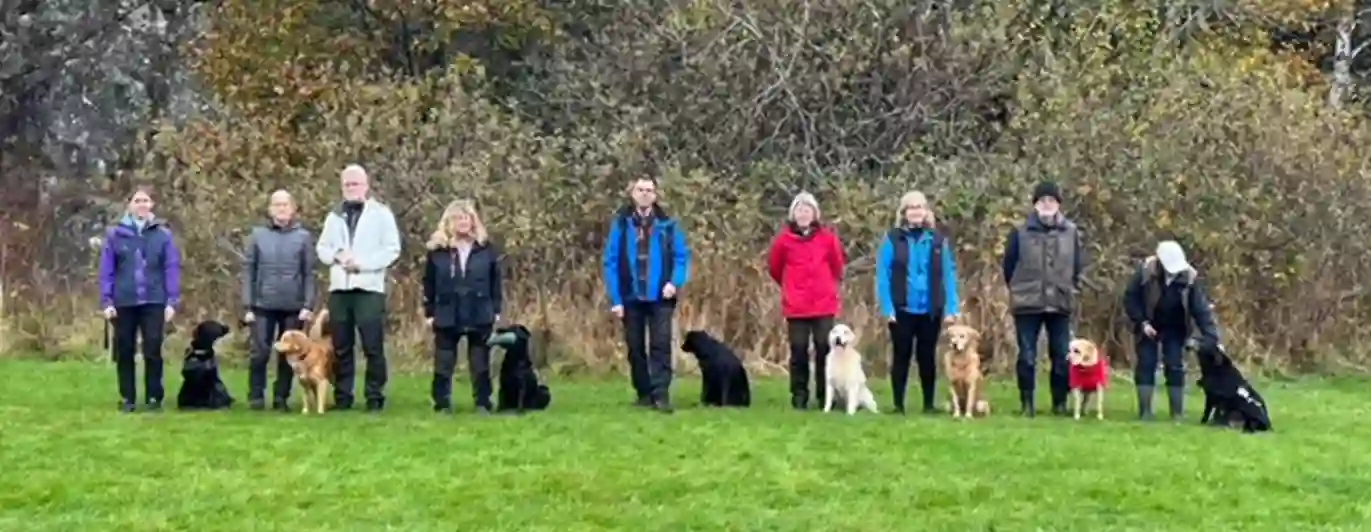 En grupp hundförare med sin hundar som tränat.