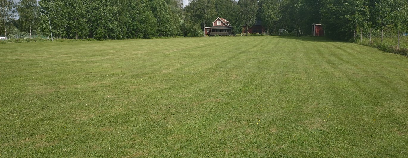 Bild på träningsplan med klubbhuset i bakgrund