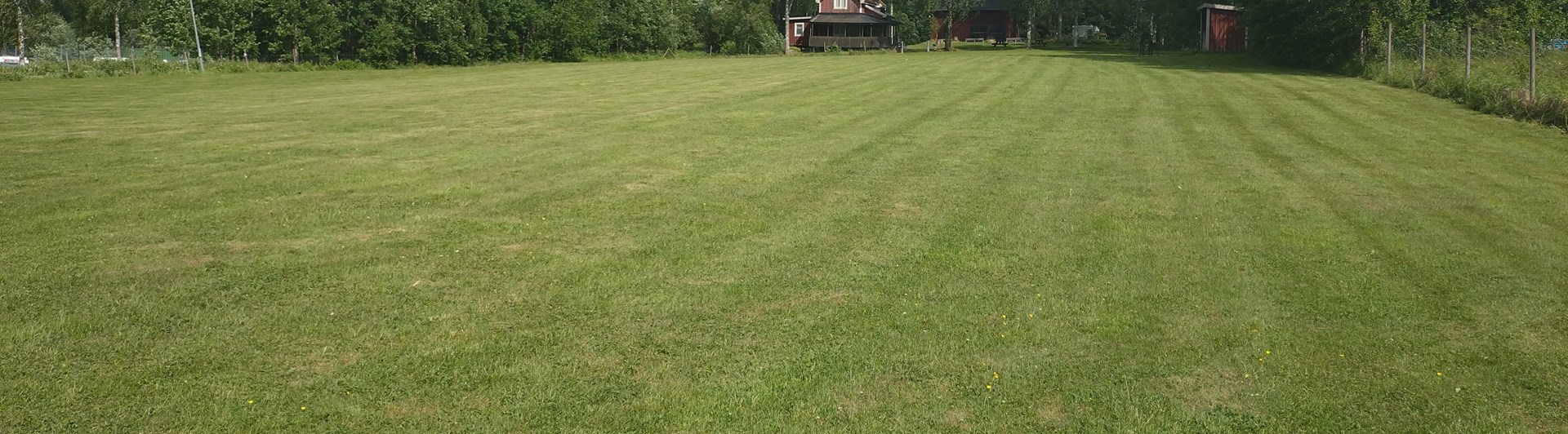 Bild på träningsplan med klubbhuset i bakgrund