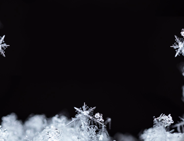 Snö som glittrar mot svart bakgrund