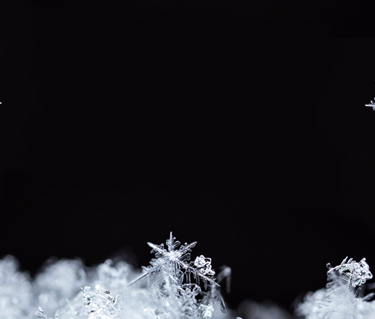 Snö som glittrar mot svart bakgrund