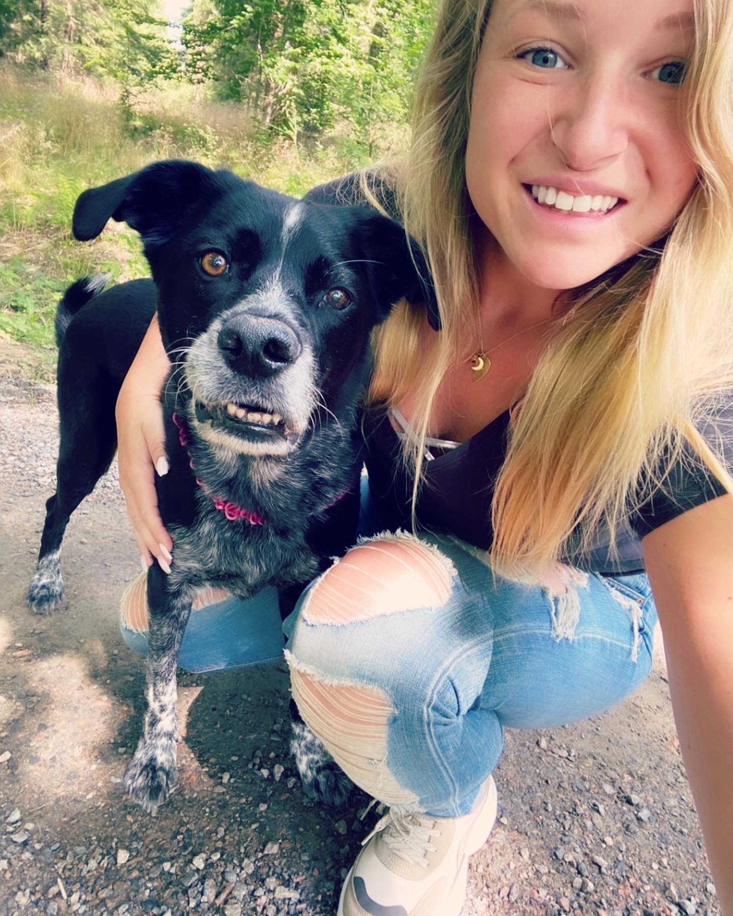 Bild på Sara Stolt som glatt håller armen om sin hund,