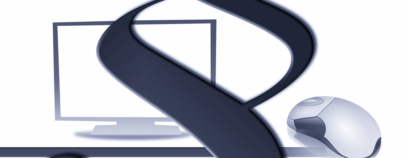 Bild på en paragraf framför en dator.