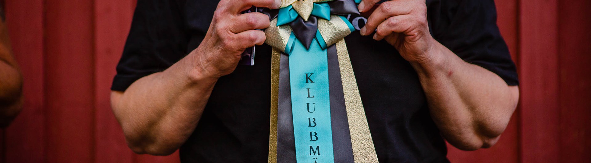 Människa håller i klubbmästerskapsrosett