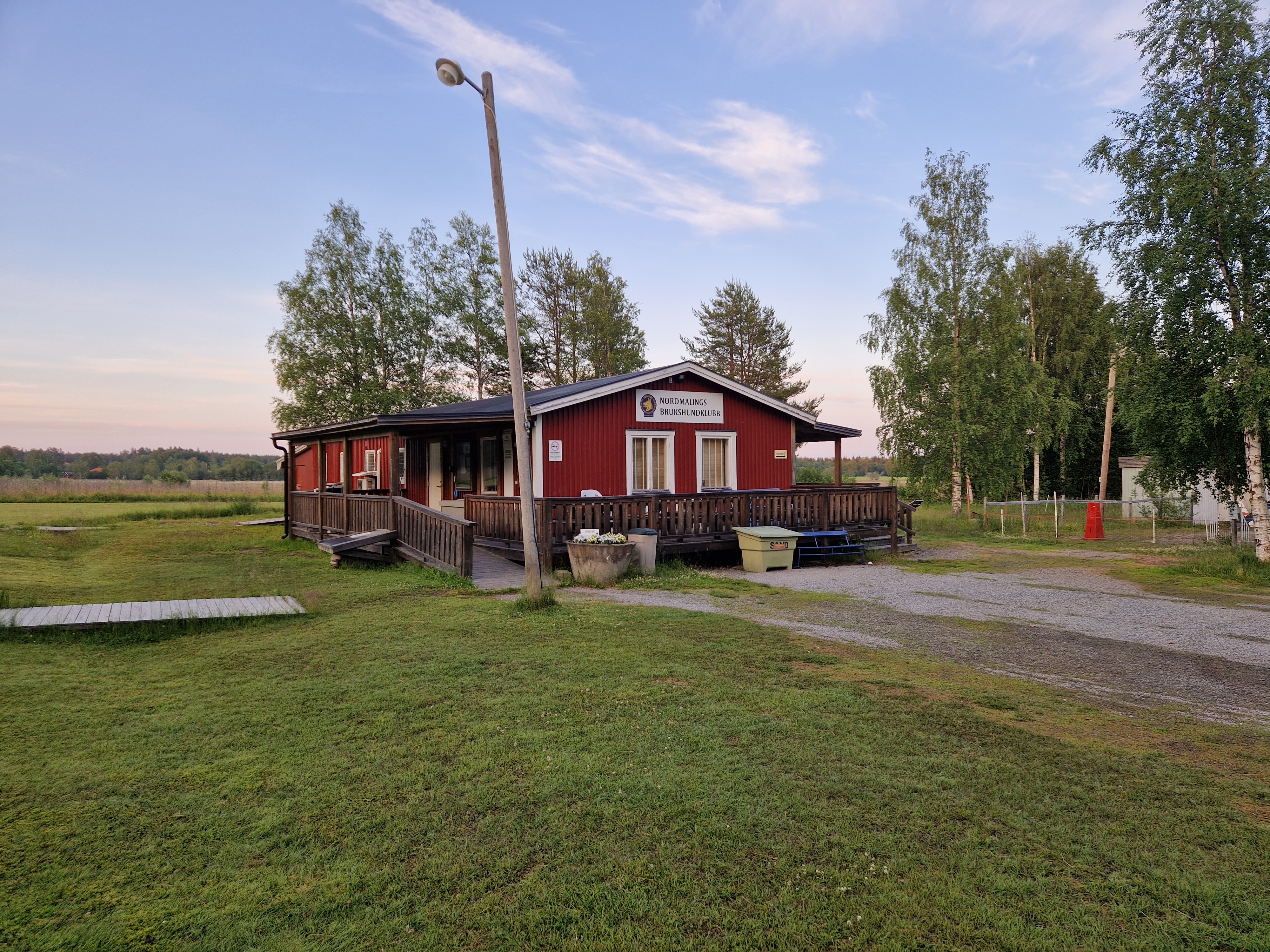 foto på klubbstuga. Rött hus med altan