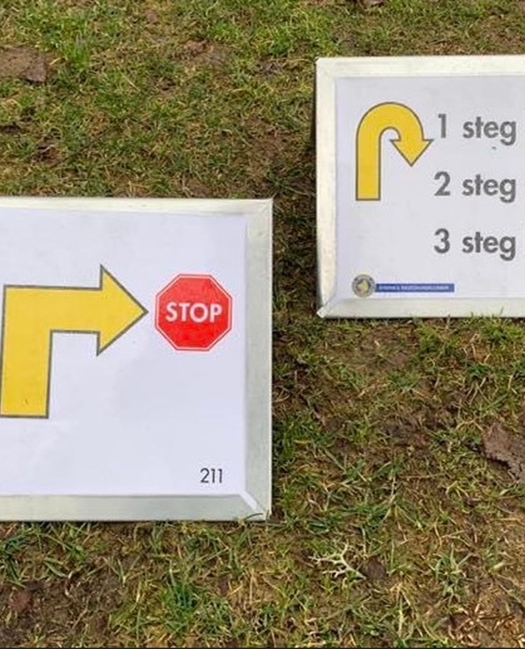 Två skyltar på moment i rallylydnad