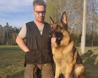 Åke med sin schäfer bredvid sig