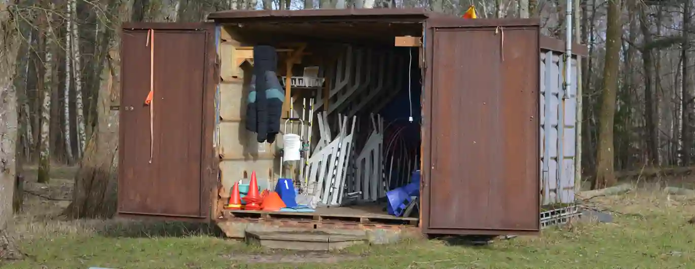 Bild på klubbens bruna container som innehåller rallylydnadsskyltar och agilityhinder.