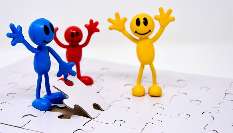 Bild som visar teamwork med pusselbitar.