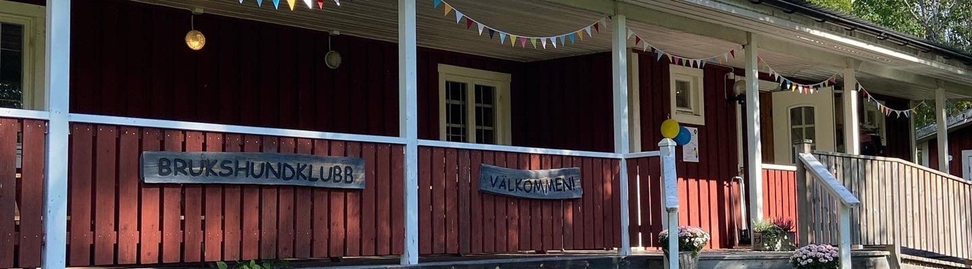 Ockelbo Brukshundklubbs klubbstuga. Bilden är tagen under Öppet hus i september-22, därför hänger färgglada girlanger och ballonger i taket.