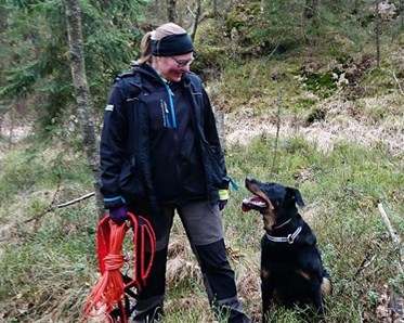En förare med sin svarta hund sittandes vid sidan