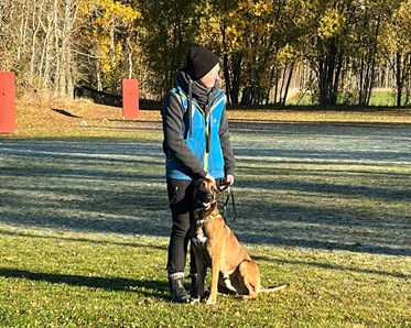 Förare med sin hund på planen
