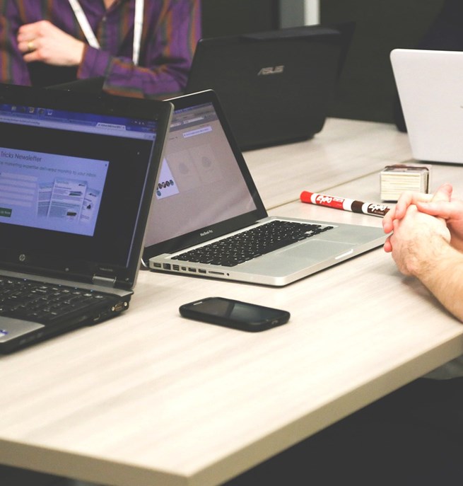 Människor vid sina datorer runt ett bord