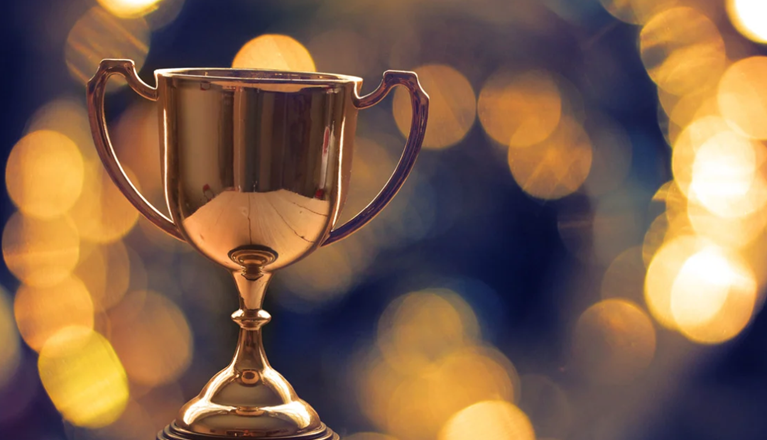 Pokal i guld mot suddig, skimrande bakgrund