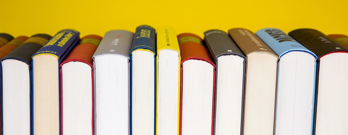 Bild som visar flera böcker framför gul bakgrund.