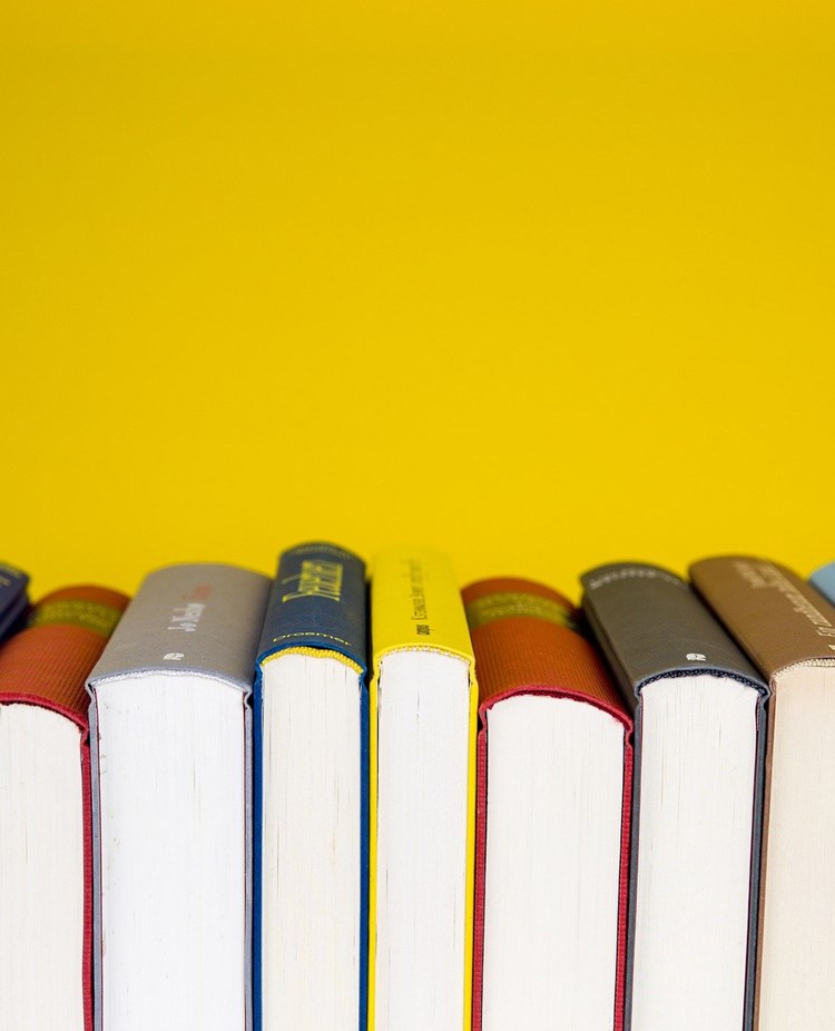 Bild som visar flera böcker framför gul bakgrund.