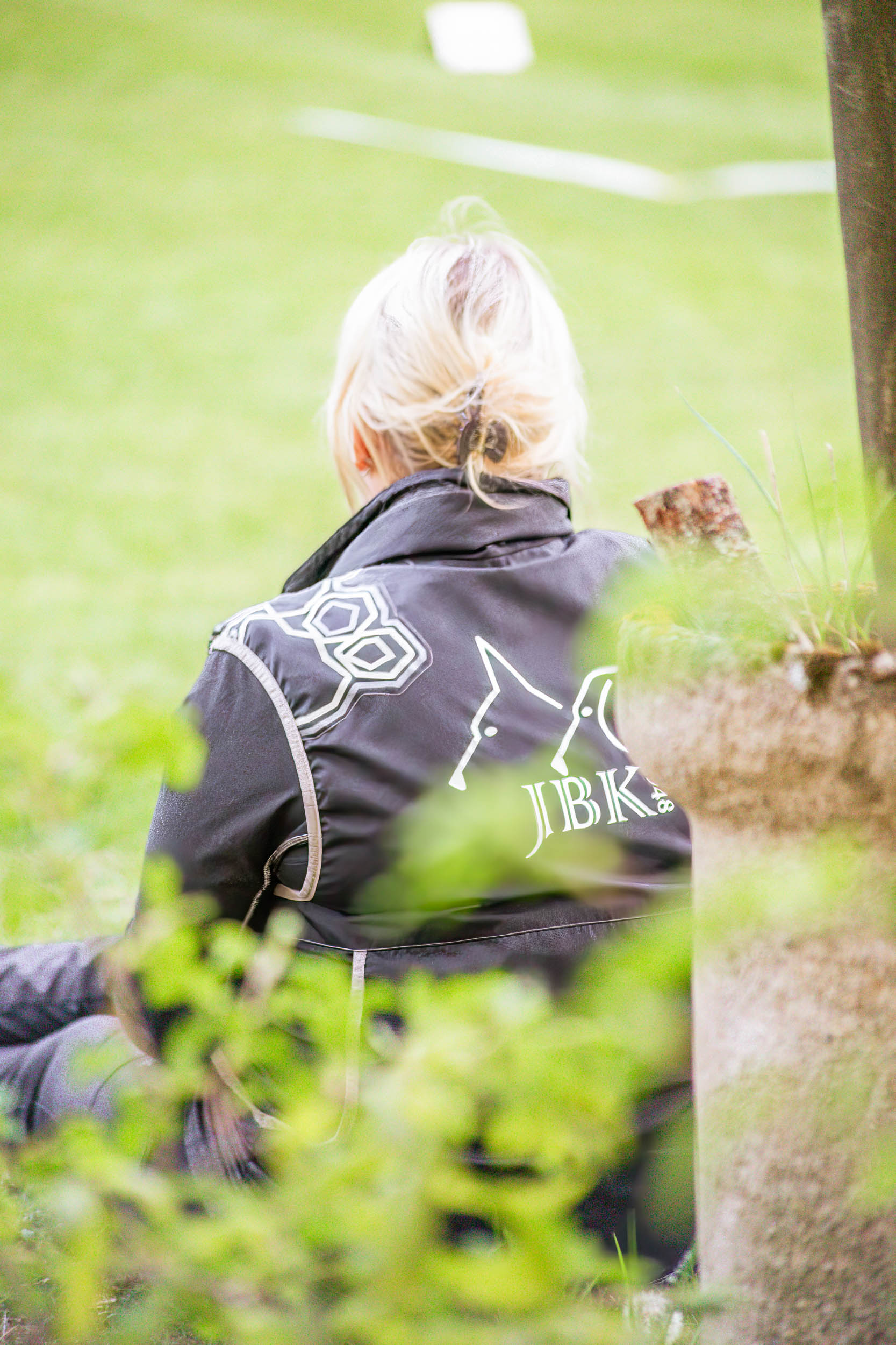 Funktionär tittar ut över gräsplan iklädd kläder från Jönköpings Brukshundklubb