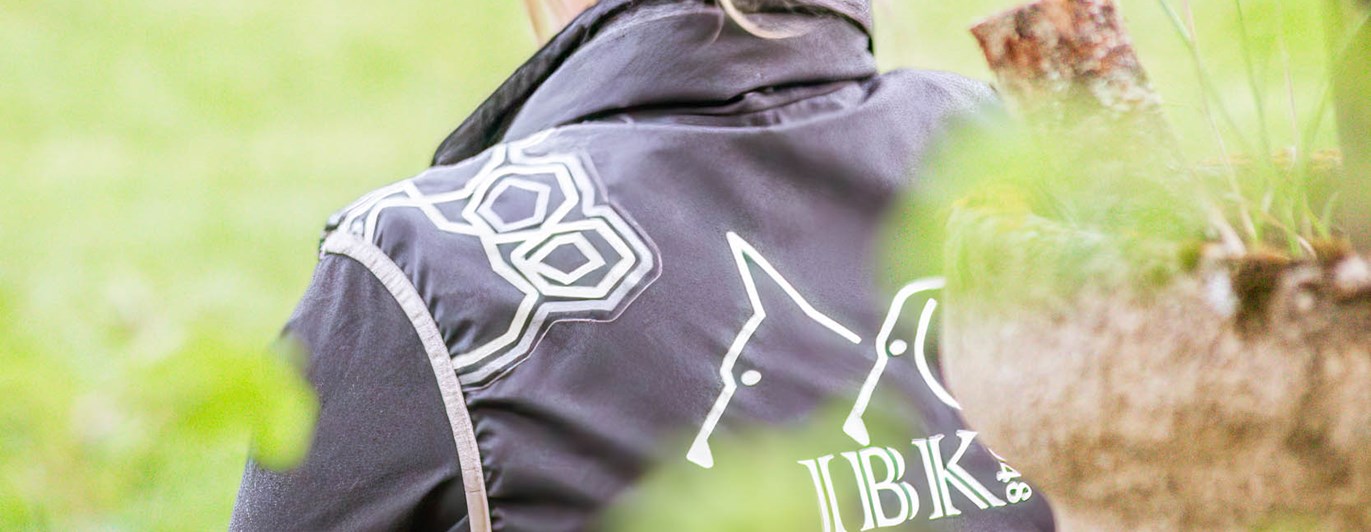 Funktionär tittar ut över gräsplan iklädd kläder från Jönköpings Brukshundklubb