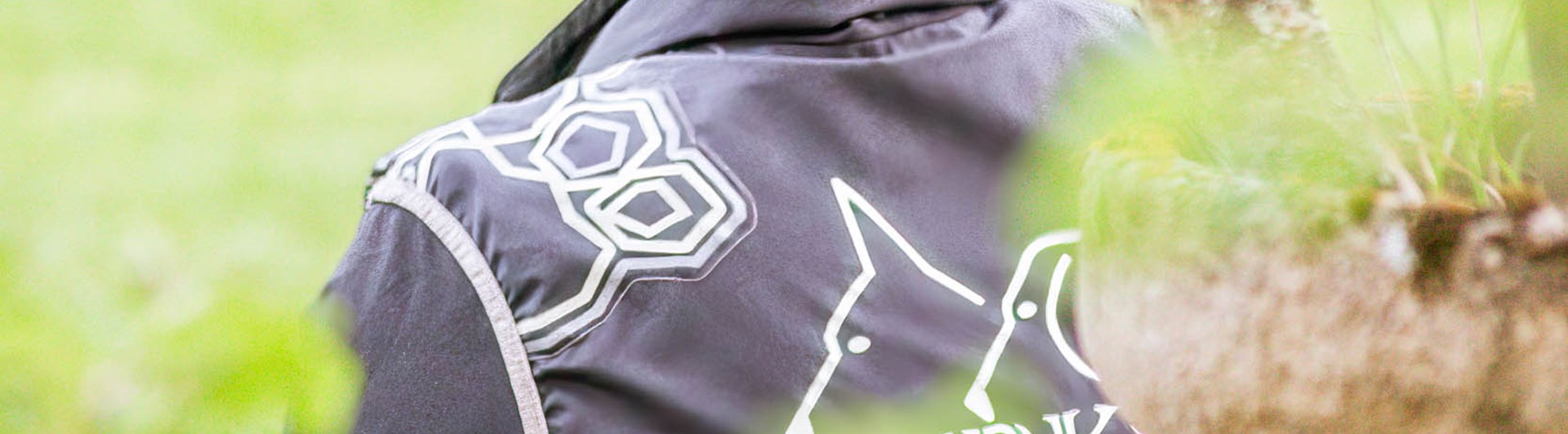 Funktionär tittar ut över gräsplan iklädd kläder från Jönköpings Brukshundklubb