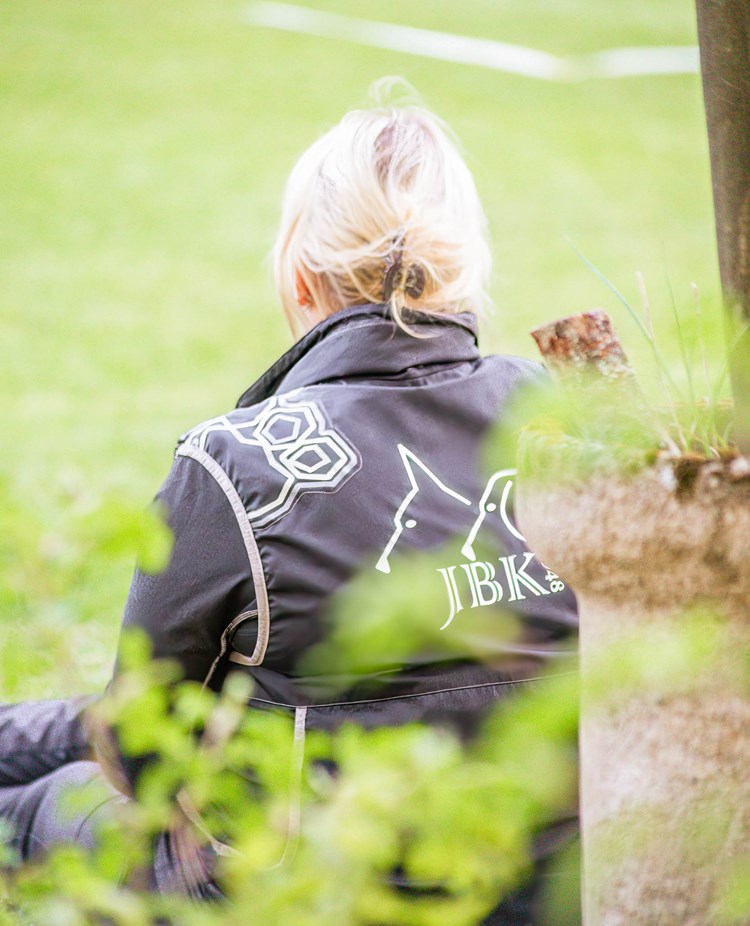 Funktionär tittar ut över gräsplan iklädd kläder från Jönköpings Brukshundklubb