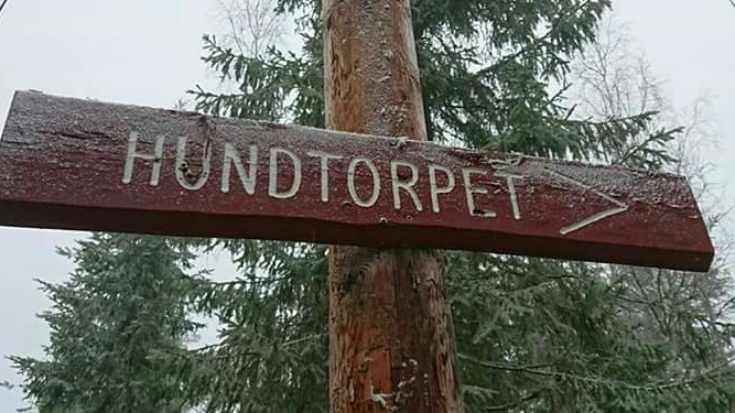 Skylt av trä med texten "Hundtorpet"