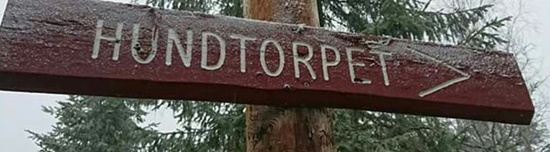 Skylt av trä med texten "Hundtorpet"