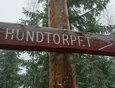Skylt av trä med texten "Hundtorpet"