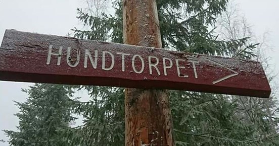 Skylt av trä med texten "Hundtorpet"