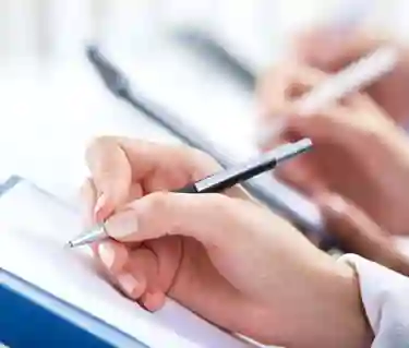Hand som håller i en penna och skriver