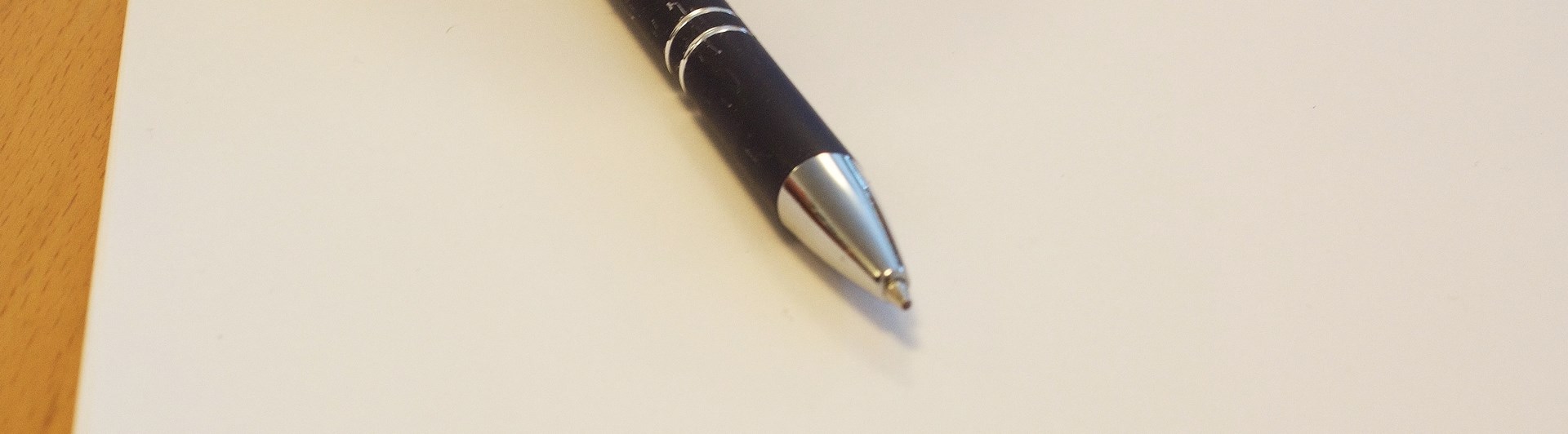 Svart bläckpenna ligger på vitt papper