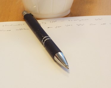 Svart bläckpenna ligger på vitt papper