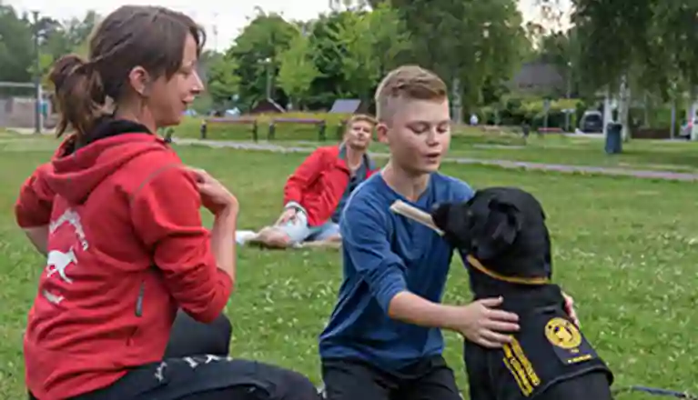 En assistanshundinstruktör instruerar en elev med hans assistanshund.
