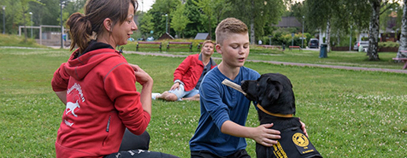 En assistanshundinstruktör instruerar en elev med hans assistanshund.