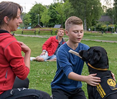 En assistanshundinstruktör instruerar en elev med hans assistanshund.