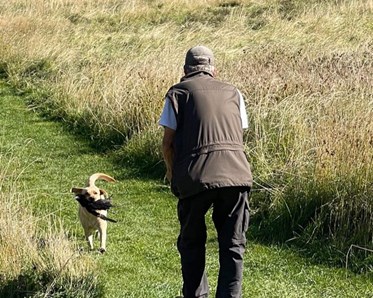 En hundförare som tränar jaktapportering med sin hund.