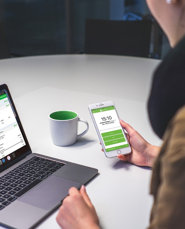 Tjej som sitter vid telefon och datorn samtidigt