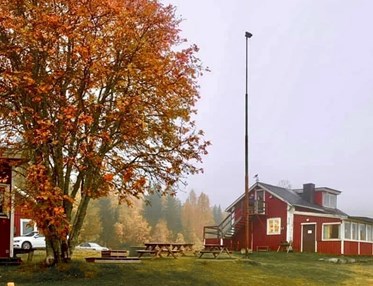 Bild på Örnsköldsviks Brukshundklubbs klubbstuga med höstfärger på träden runtom