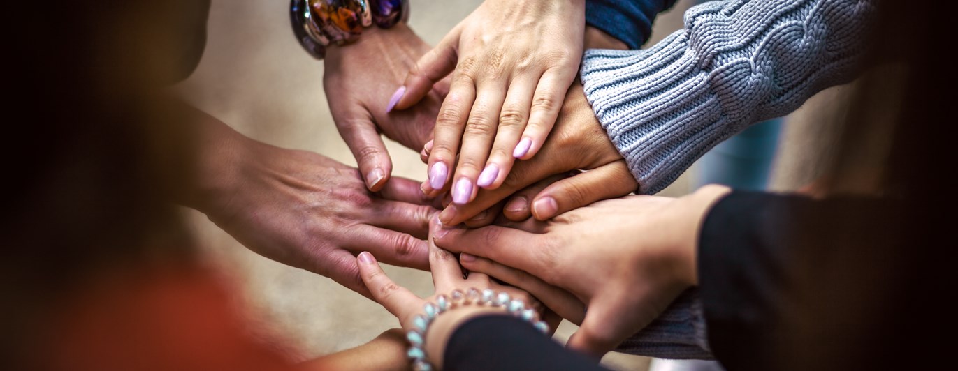 Bild som visar ett antal händer som möts och visar en känsla av gemenskap och samarbete.