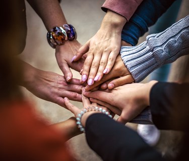 Bild som visar ett antal händer som möts och visar en känsla av gemenskap och samarbete.