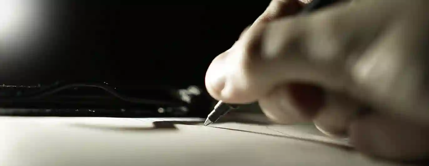Bild som visar skrivande hand med kulspetspenna.