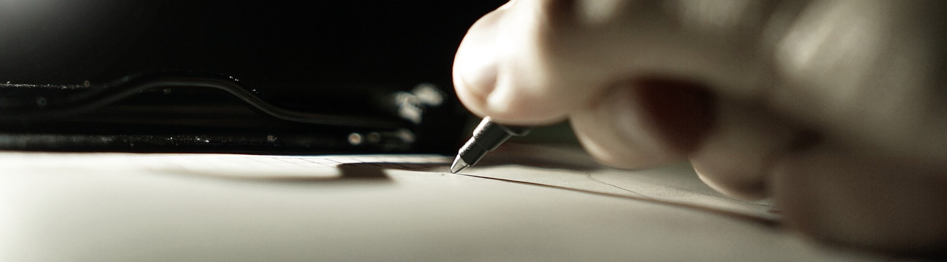 Bild som visar skrivande hand med kulspetspenna.