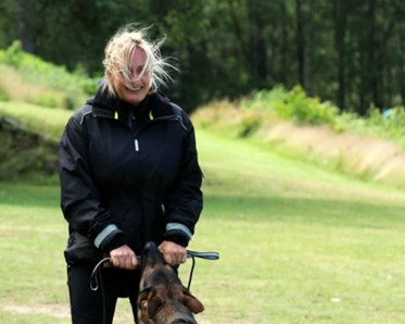 Kvinna som leker med sin hund. De har dragkamp.