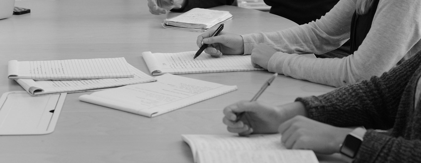 Bild på mötesdeltagare som skriver.