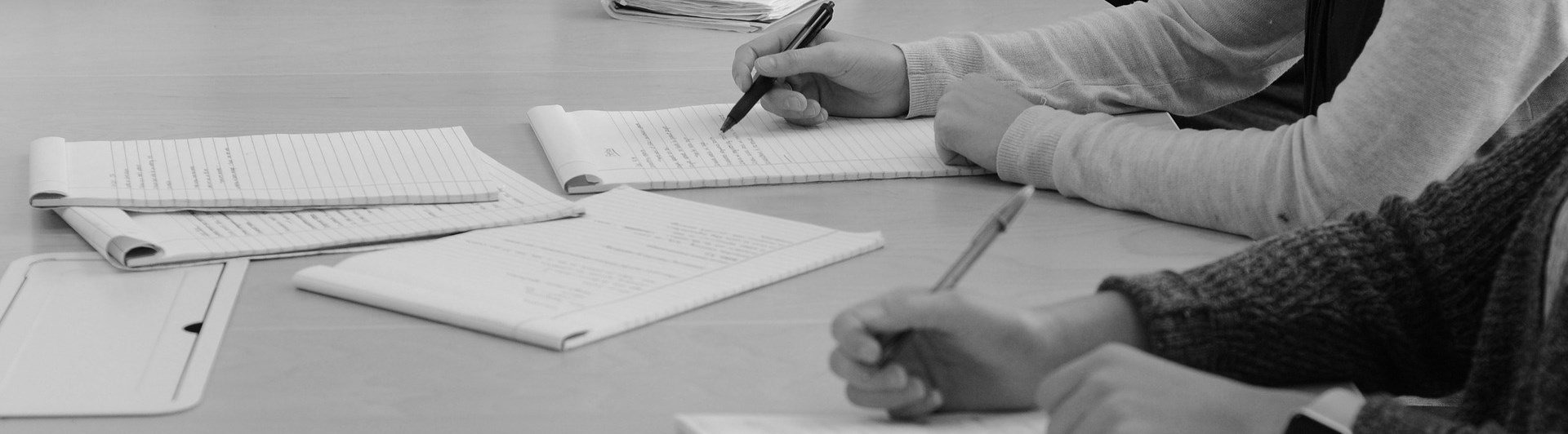 Bild på mötesdeltagare som skriver.