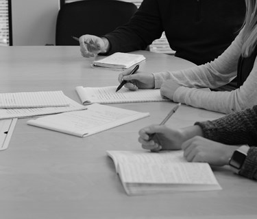 Bild på mötesdeltagare som skriver.