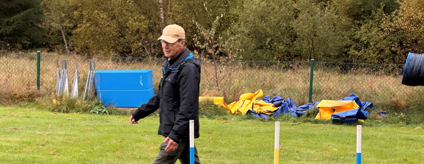 En hund med förare går slalom i Agility