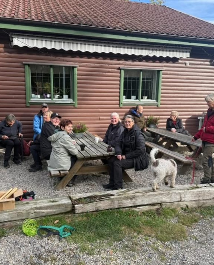 Människor sitter utomhus framför ett klubbhus