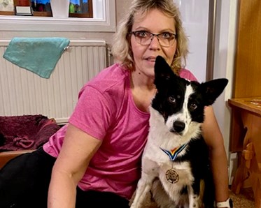 Bordercollie sitter soffan tillsammans med sin matte