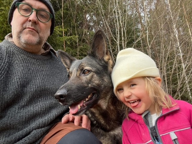 Man med schäferhund och dotter