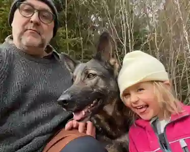 Man med schäferhund och dotter